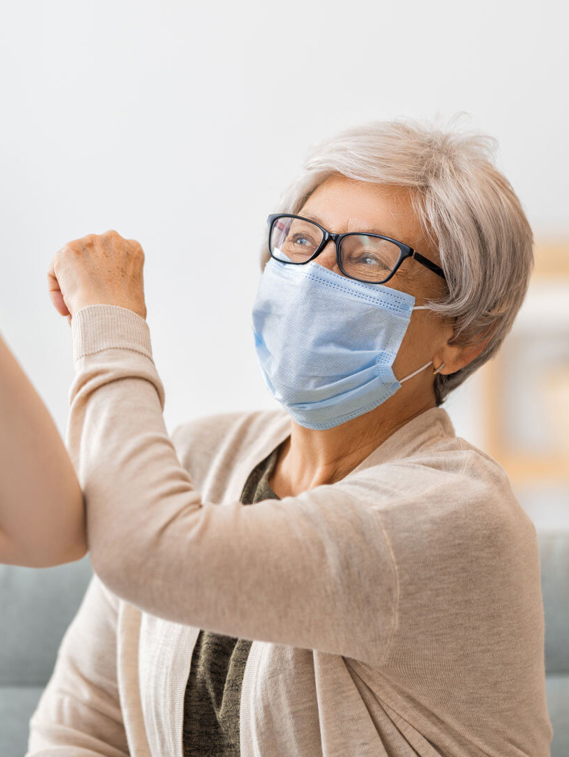 nurse elbow high fiving elderly female patient