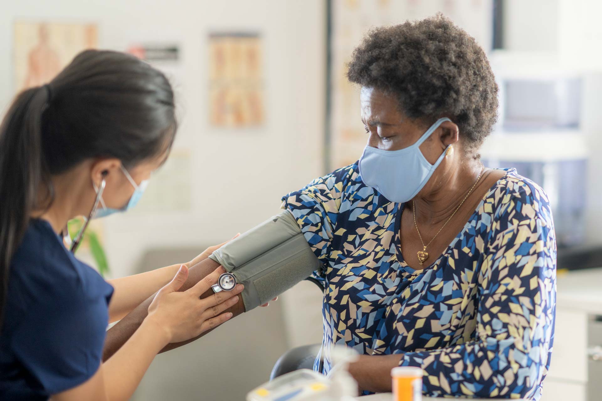 nurse taking blood pressure of woman